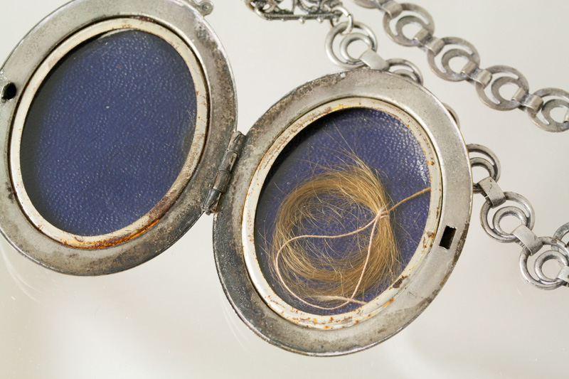 antique silver locket, opened to reveal lock of hair
